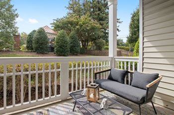 A patio with a couch and a table on a porch